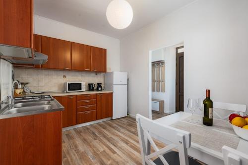 a kitchen with wooden cabinets and a table with a bottle of wine at MIMA house with apartments in Savudrija