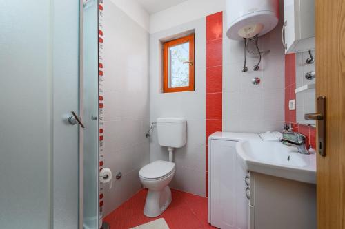 a small bathroom with a toilet and a sink at MIMA house with apartments in Savudrija