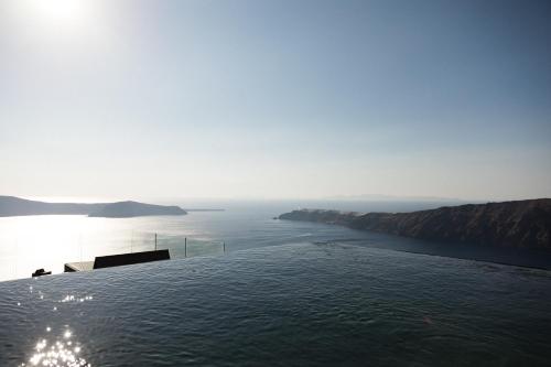 a swimming pool with a view of the ocean at Galaxy Suites & Villas in Imerovigli