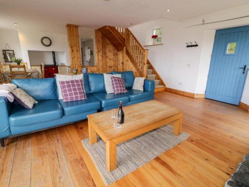 a living room with a blue couch and a coffee table at Lough View Cottage in Carrigart