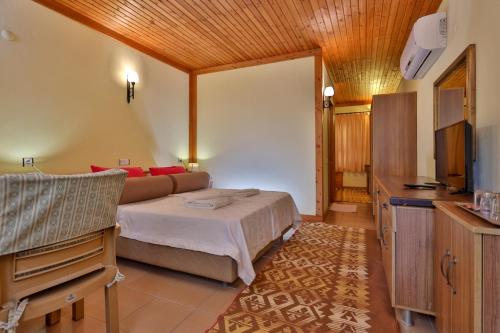 a bedroom with a bed and a television in a room at Çıralı Orange Motel in Cıralı