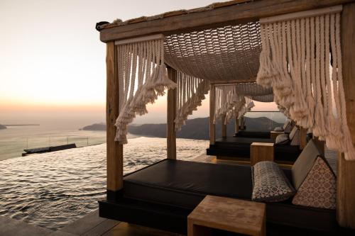 a room with a bed and a view of the ocean at Galaxy Suites & Villas in Imerovigli