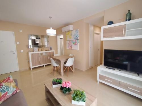 sala de estar con TV, mesa y sillas en ACV - Miramar-1ª linea planta 4 Sur, en Oropesa del Mar