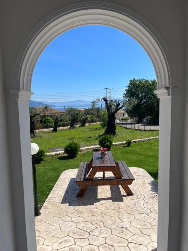 an archway with a picnic table in a field at Ilias Apartments Dassia By Hotelius in Dassia
