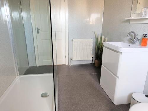 a bathroom with a shower and a toilet and a sink at Granby House in Llandudno