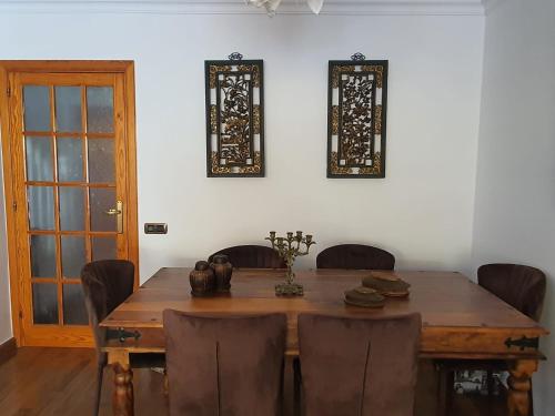 ein Esszimmer mit einem Holztisch und Stühlen in der Unterkunft Suites Beach House in Playa de las Americas