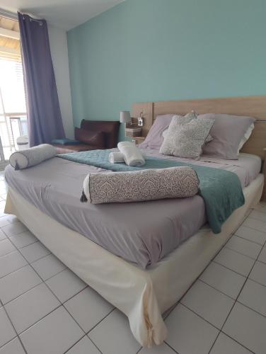 un grande letto posto in cima a un pavimento bianco di Studio vue mer et rocher du Diamant Antilles a Le Diamant