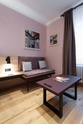 a living room with a couch and a table at Altstadthotel Kasererbräu in Salzburg