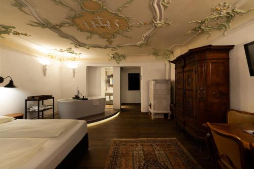 a bedroom with a bed and a ceiling at Altstadthotel Kasererbräu in Salzburg