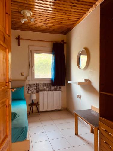 a room with a bed and a table and a window at Nadia's Beach House in Pefkari