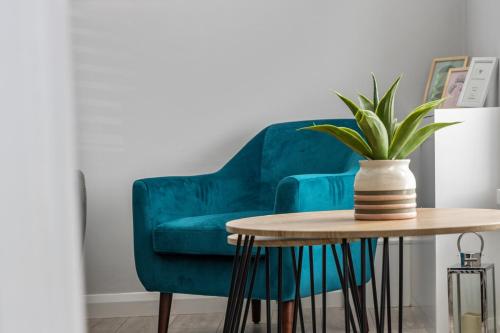 a green chair and a table with a potted plant at The Green Door in Downpatrick