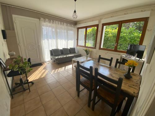 a living room with a table and chairs and a couch at Maison avec jardin in Béthune