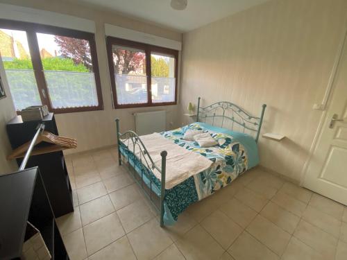 a bedroom with a bed in a room with windows at Maison avec jardin in Béthune