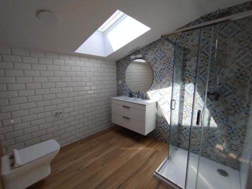 a bathroom with a shower and a toilet and a skylight at Apartmány Adam in Liptovská Teplá