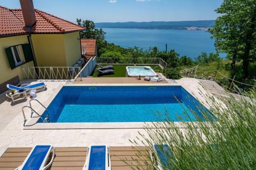 una piscina con vista sull'acqua di Villa Maruncela with sea and island views, 5 bedrooms, private pool, gym a Lokva Rogoznica