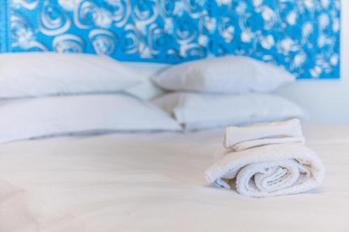 a white towel sitting on a bed with pillows at Yzerfontein Villa Fantastica - No Loadshedding in Yzerfontein