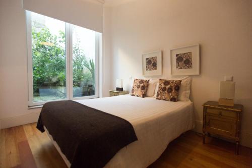 ein Schlafzimmer mit einem großen Bett und einem großen Fenster in der Unterkunft Citybreak-apartments Bolhao in Porto