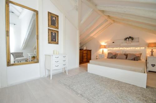 a white bedroom with a large bed and a mirror at Villa Bocca del Perasto in Perast
