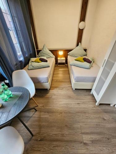 a room with two beds and a table at Hotel & Hostel Albstadt in Albstadt