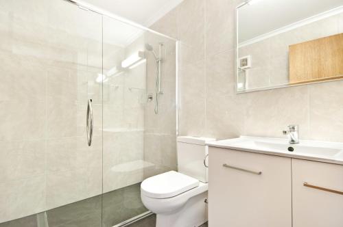 a bathroom with a shower and a toilet and a sink at Whalers Rest Motor Inn in Portland