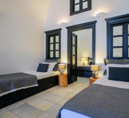 a bedroom with two beds and a mirror at Firalia, Casa in Rock Suites in Fira