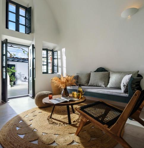 a living room with a couch and a table at Firalia, Casa in Rock Suites in Fira