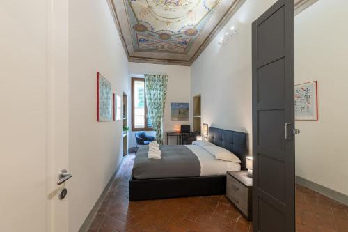 une chambre avec un lit et un plafond dans l'établissement PITTI Suite, à Florence