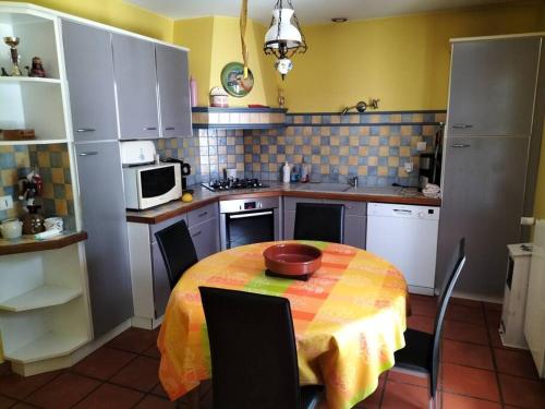 a kitchen with a table with a bowl on it at Chez Coco maison au coeur du parc régional du Quercy in Issendolus