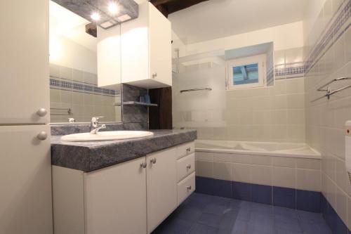 a bathroom with a sink and a tub and a toilet at Maison etxebarnia cote in Mendive