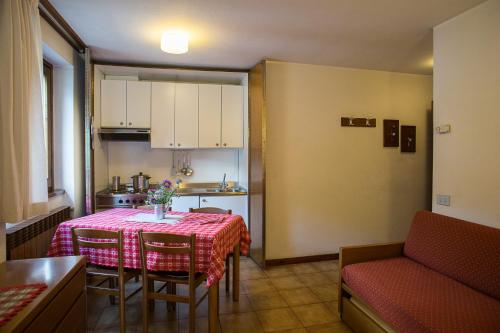 eine kleine Küche mit einem Tisch und Stühlen in einem Zimmer in der Unterkunft Residence Valfurva in Santa Caterina Valfurva