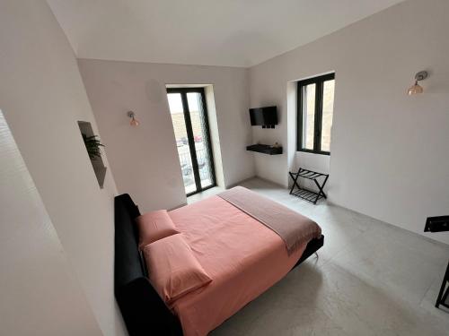 a bedroom with a pink bed in a white room at La Casa Di Chloe in Syracuse