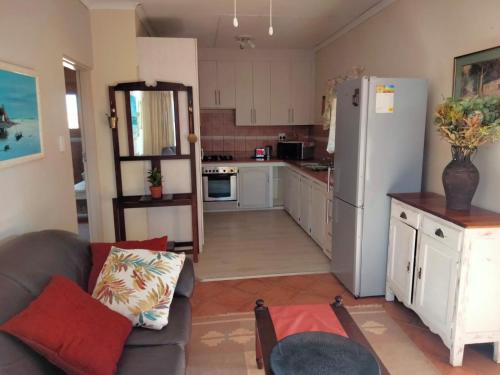 a kitchen with a couch and a refrigerator at At Home Apartments in Mokopane