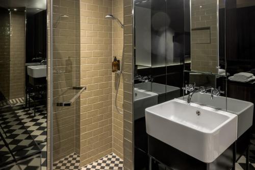 a bathroom with a sink and a glass shower at Hotel MANI by AMANO in Berlin