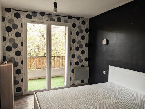 Schlafzimmer mit einem Bett und einem Fenster in der Unterkunft Le Pharo in Martigues
