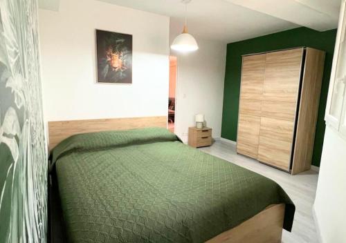 - une chambre avec un lit vert et un placard dans l'établissement Chez Aïda-Centre Ville Poitiers-La Conciergerie., à Poitiers