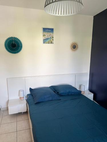 - une chambre avec un lit bleu et deux miroirs dans l'établissement Appartement cosy, à Six-Fours-les-Plages
