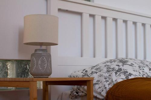 a lamp sitting on a table next to a pillow at Central Park Apartment in Cluj-Napoca