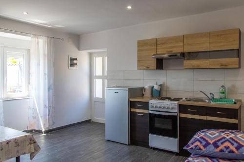 a small kitchen with a stove and a sink at Apartments Teo in Opatija