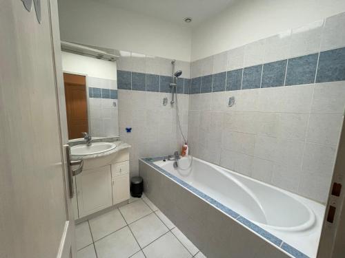 ein Badezimmer mit einer Badewanne und einem Waschbecken in der Unterkunft L'ambre salée in Gujan-Mestras