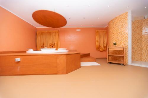 a bathroom with orange walls and a sink and a mirror at Hotel America in Marina di Camerota