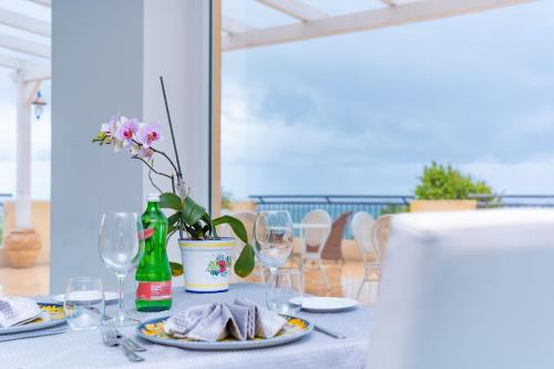 a table with a plate of food and wine glasses at Hotel America in Marina di Camerota