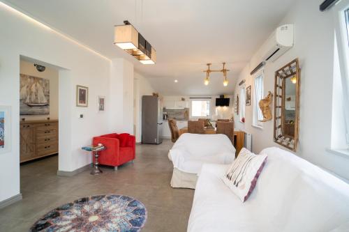 - un salon avec un canapé blanc et un fauteuil rouge dans l'établissement Villa ANNA-LENA with pool close to sandy beach, à Garica