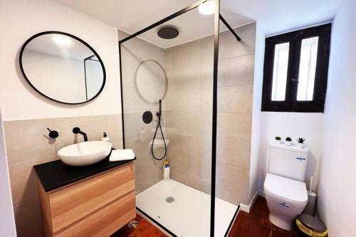 een badkamer met een wastafel, een toilet en een spiegel bij Fantástico Loft junto al Mar de Cudillero by Batuecas in Cudillero