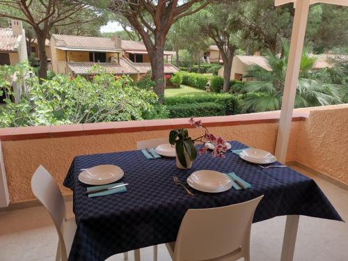 einen Tisch mit Tellern und Servietten auf einem blauen Tischtuch in der Unterkunft Appartamento due passi dal mare in Fort Village