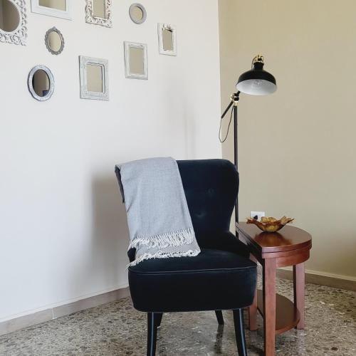 a blue chair sitting next to a table with a lamp at Sole raggiante Lia Darzillo in Afragola
