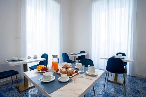 a dining room with tables and chairs with a tray of food at Relais al Castello in Castellammare di Stabia