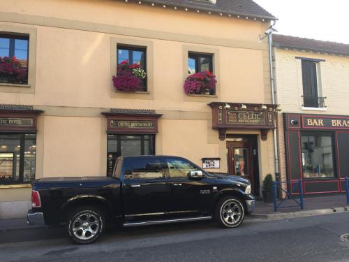 a black truck parked in front of a building at Le Celtic in Le Thillay
