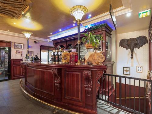 a bar in a pub with an elephant on the wall at Le Celtic in Le Thillay
