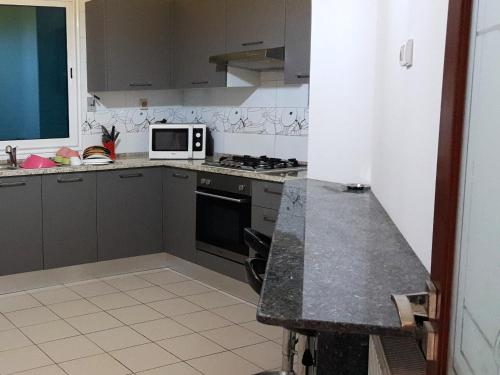 a kitchen with a stove and a microwave at Le luxe du Lac in Tunis