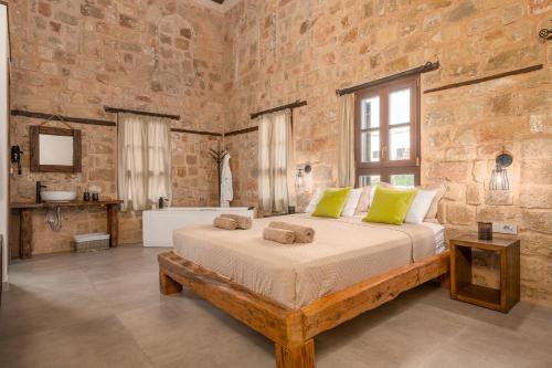 ein Schlafzimmer mit einem großen Bett in einer Ziegelwand in der Unterkunft Ancient Knights Luxury Suites in Rhodos (Stadt)